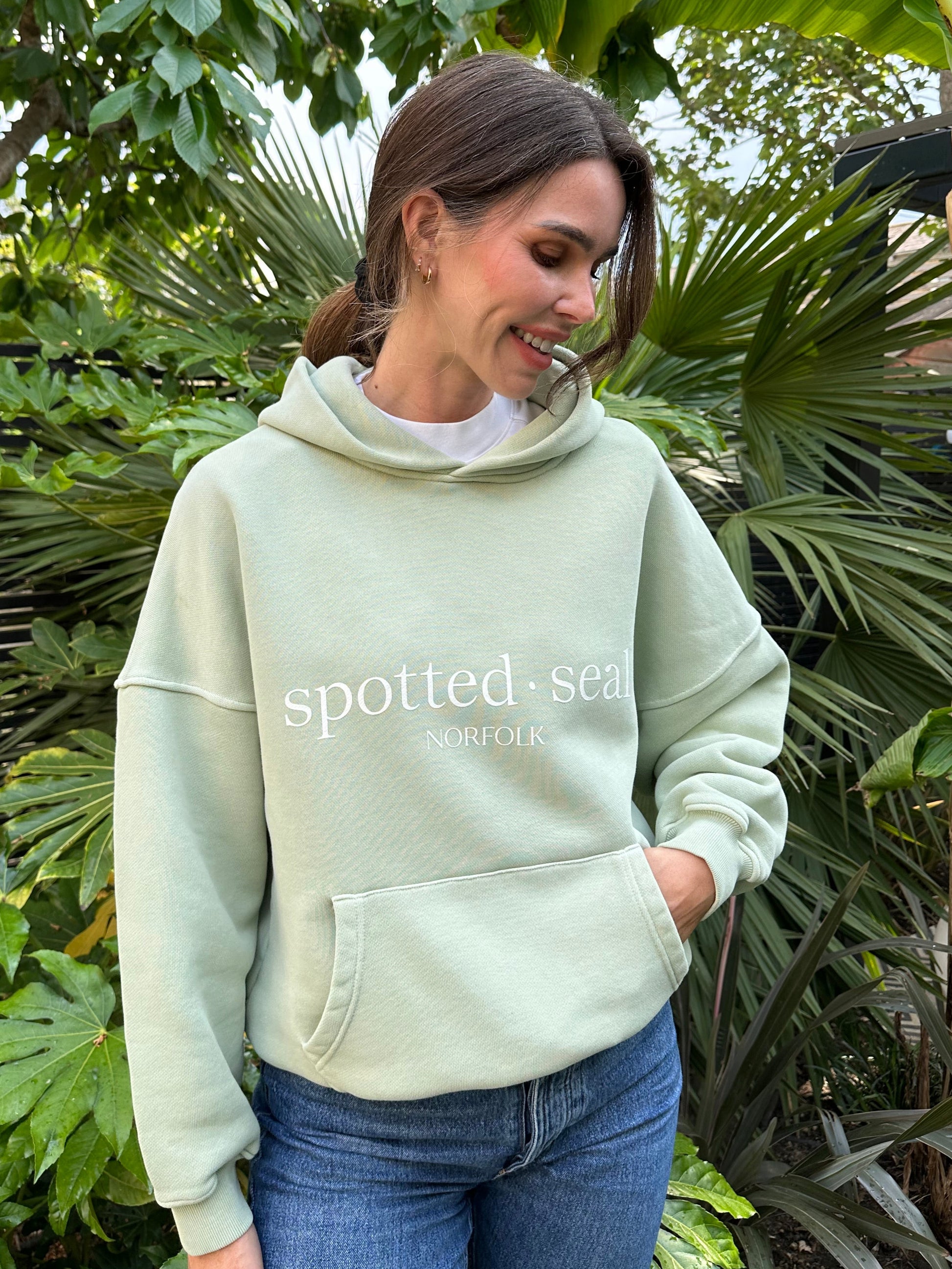 Model wearing spotted-seal slouch oversized hoodie in sea foam green