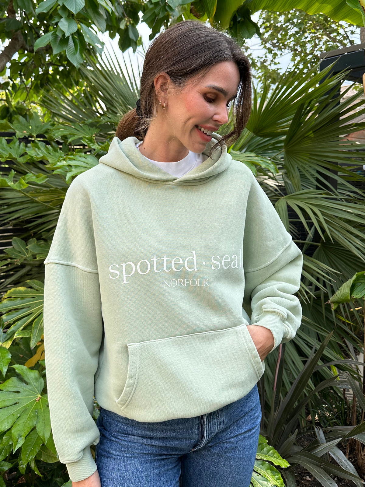 Model wearing spotted-seal slouch oversized hoodie in sea foam green