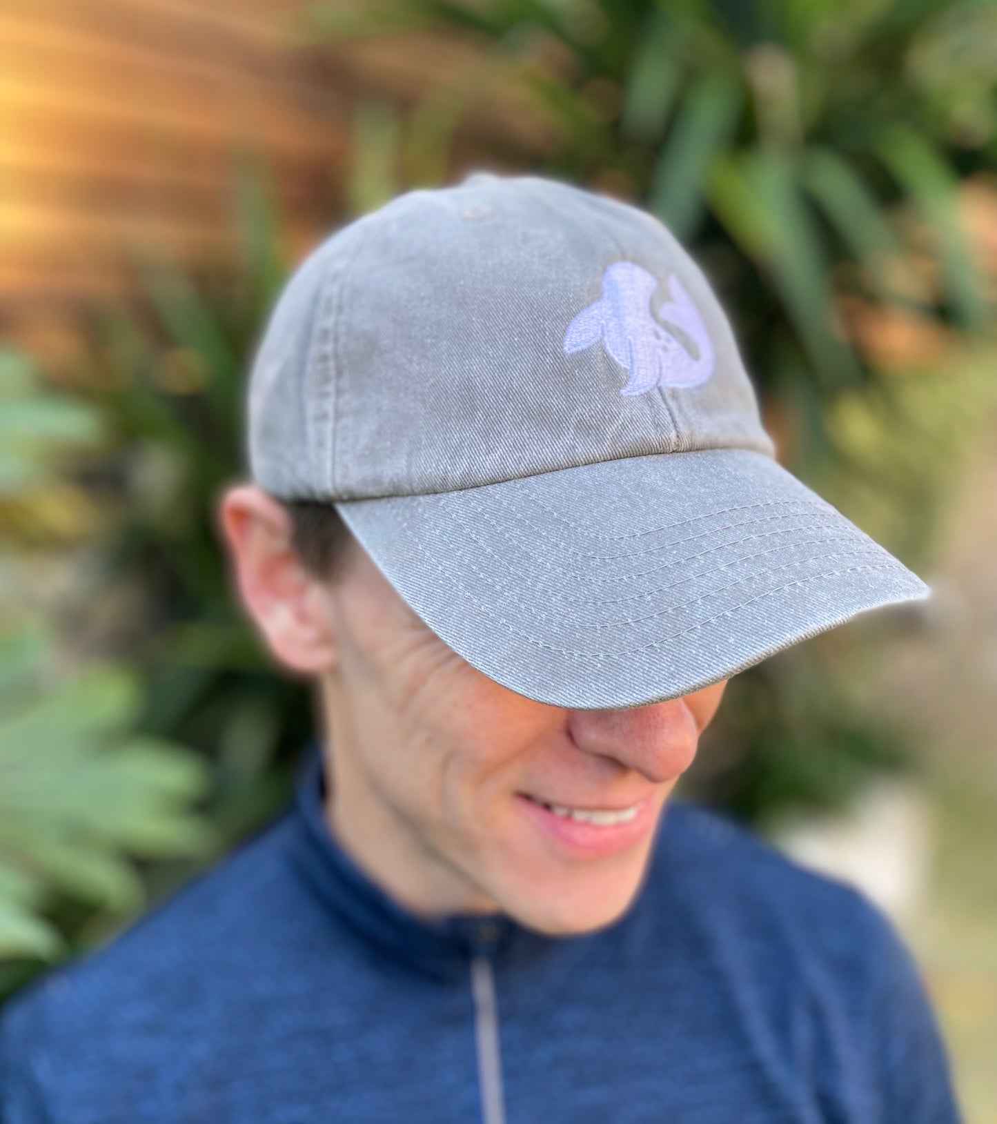 model wearing spotted-seal unisex cap in grey tone shingle colour with embroidered seal