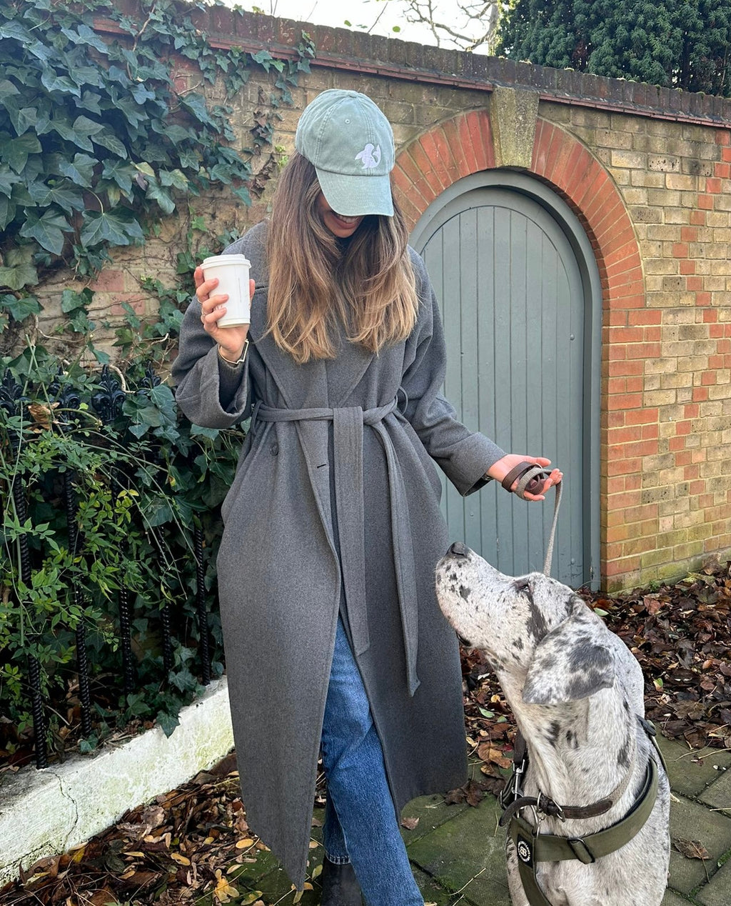 Model in spotted-seal unisex cap in samphire with Great Dane 
